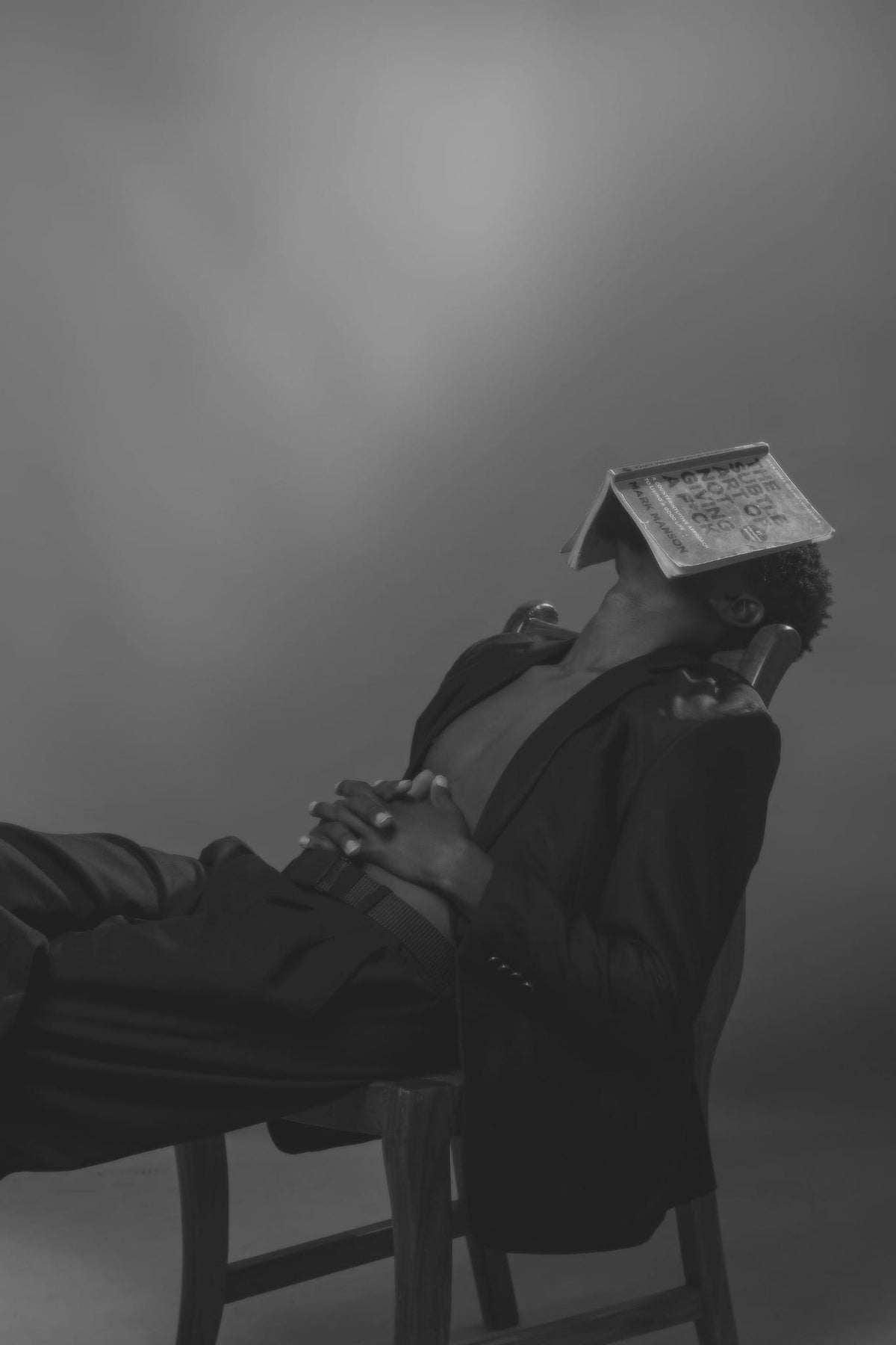 A reclining reader resting with an open book over their face.